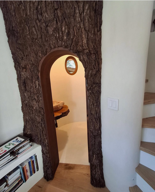 Hand-sculpted tree-trunk archway in decorative plaster — treehouse interior