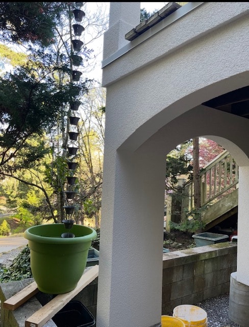 EIFS arched column and smooth finish patio exterior with lush garden backdrop