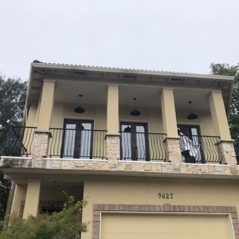 Stucco and EIFS estate with decorative columns and wrought-iron balcony