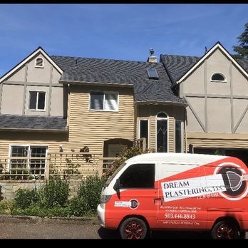 Tudor-style home with EIFS exterior and Dream Plastering service van in driveway