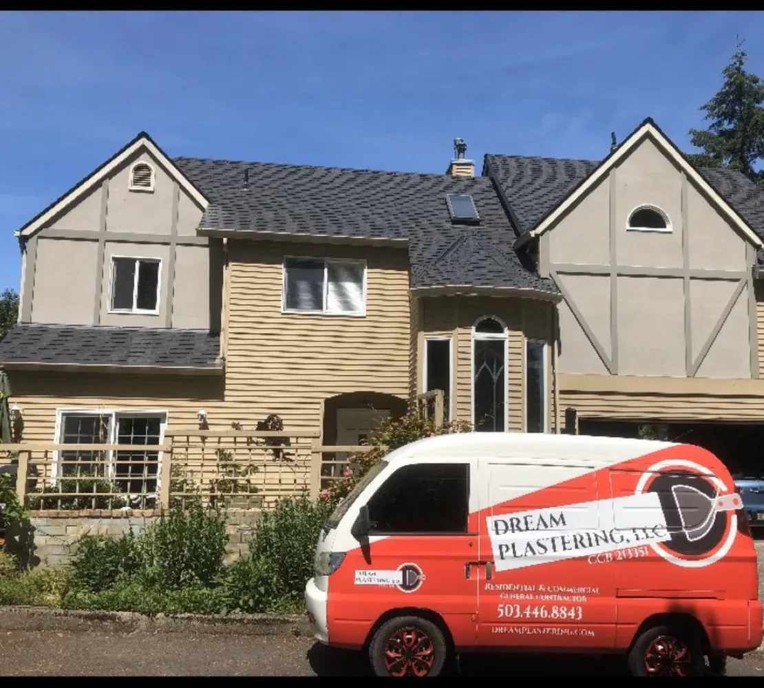 Dream Plastering van parked in front of Tudor stucco home