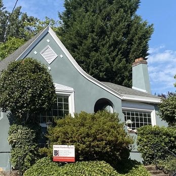 Green stucco craftsman bungalow with Dream Plastering sign