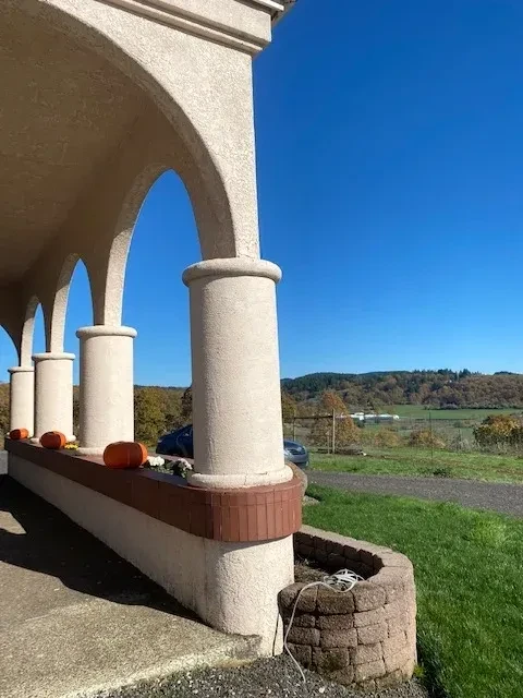 Stucco arched columns and loggia with rural valley view and pumpkins