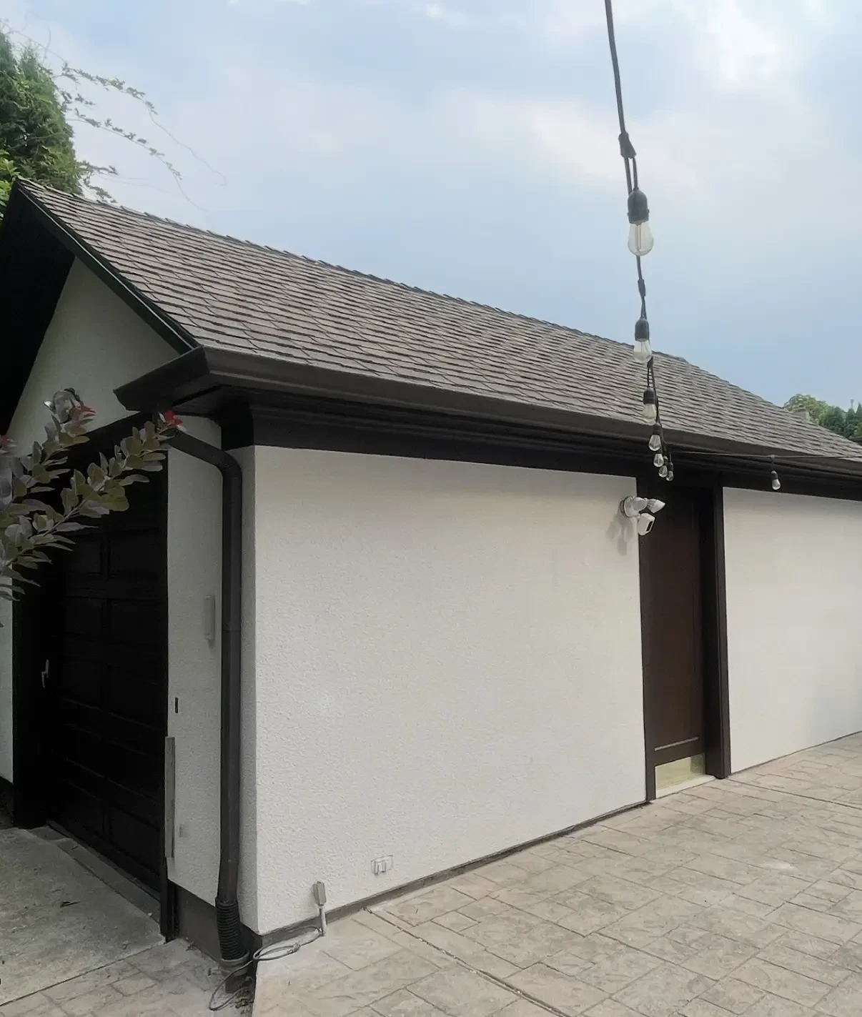 Fresh stucco exterior detail on residential garage with dark trim
