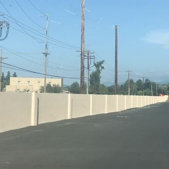 Long stucco-finished retaining wall along roadway